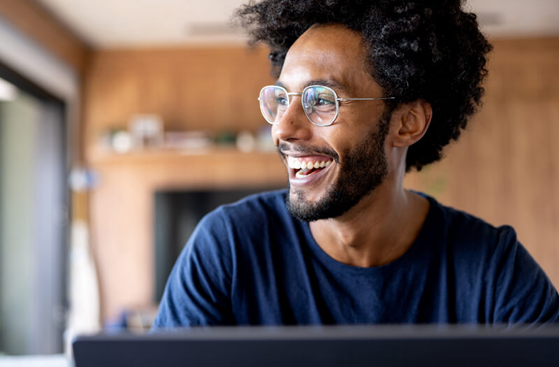 Google Cloud Security Happy businessman smiling while workign off secure computer using Google Cloud