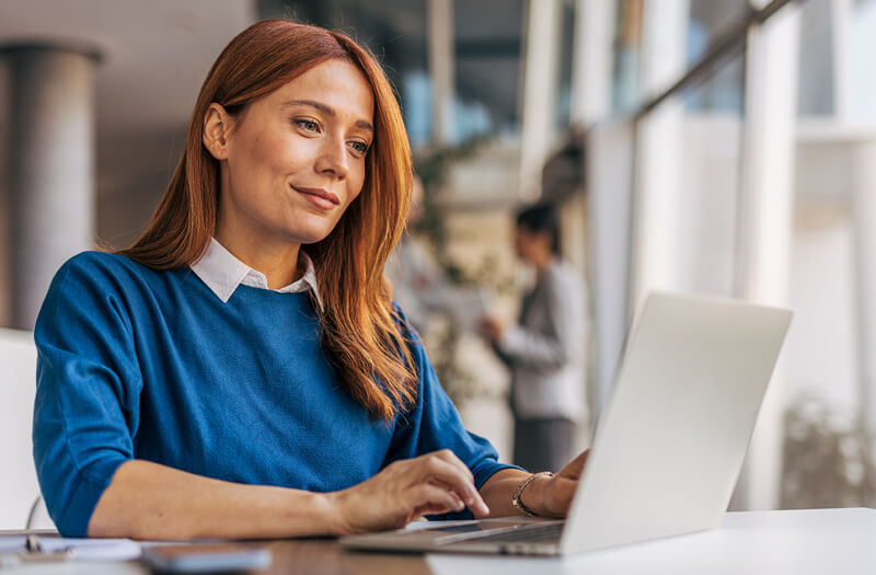 Businesswoman using laptop wioth Gemini Enterprise in office