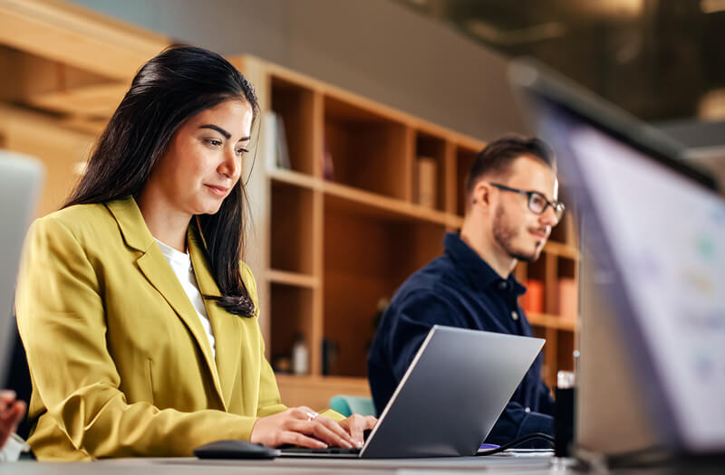 Business professional working off laptop remotely in modern office setting