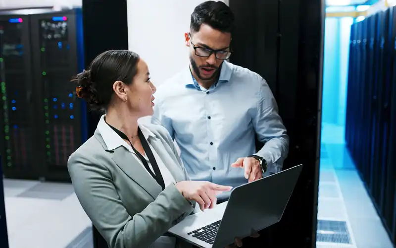 People in data center on laptop.