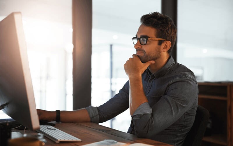 Man smiling while working on monitor screen