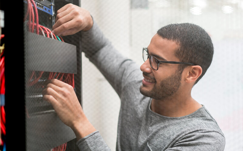 IT technician working with cables in data center