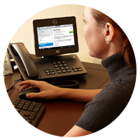 Woman at keyboard next to phone.