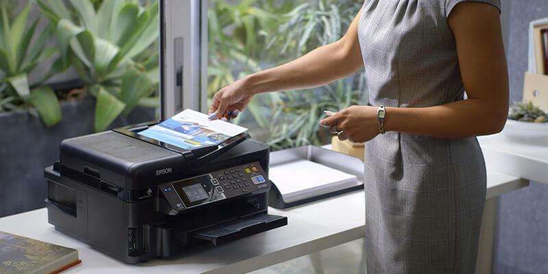 Business woman grabbing printed paper from Epson printer