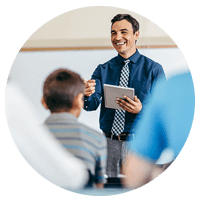 Teacher instructing students at front of classroom.