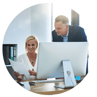 Smiling businessman and woman working on desktop computer