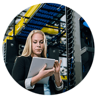 IT engineer reviewing server information off tablet computer in modern data center