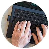 Hands typing on laptop keyboard