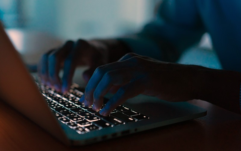 Close up of hands typing on a laptop keyboard. Cyber security, Ransomware protection, cyberattack security