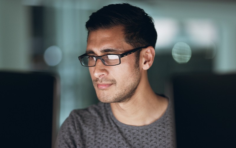 Man with glasses on computer