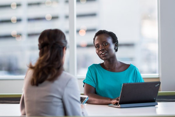 Two woman use a laptop to have a meeting