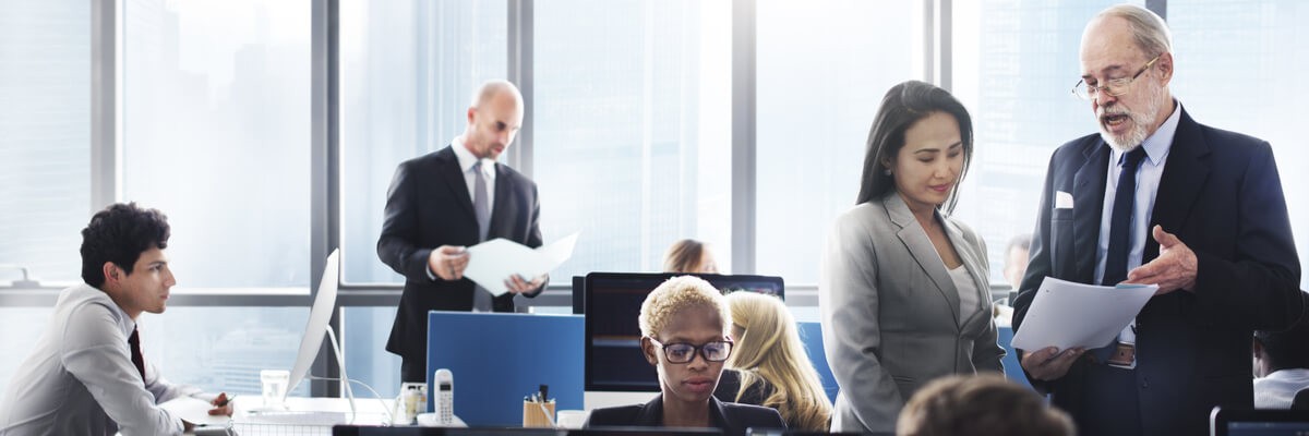 IT professionals talking while looking at papers and devices