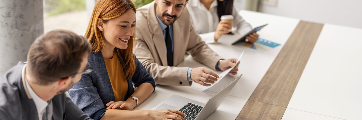 Girl smiling in a meeting looking at a laptop