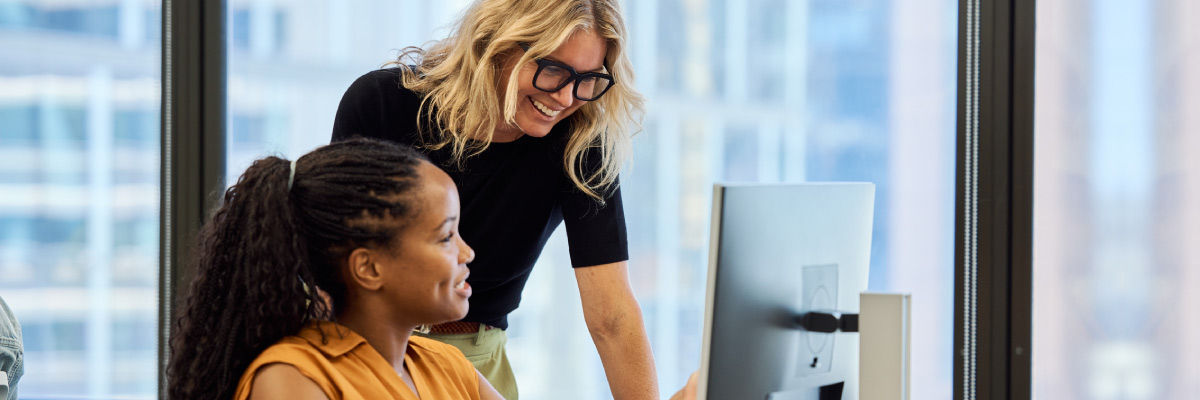 Coworkers smiling and laughing together on computer
