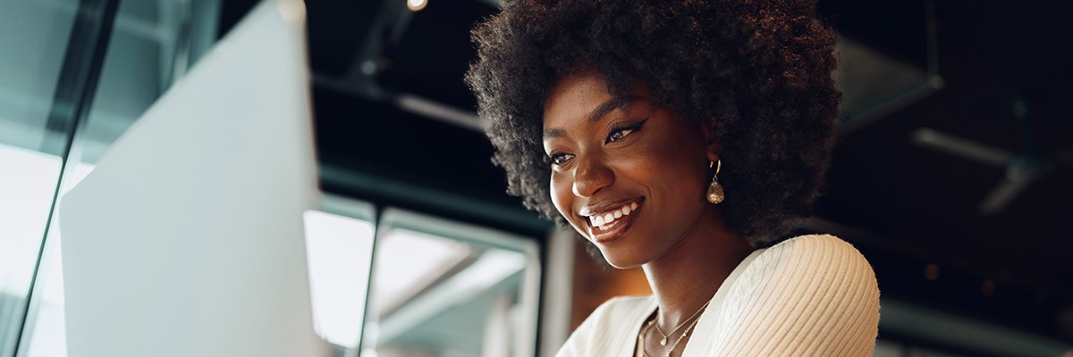 Woman smiling while working on laptop