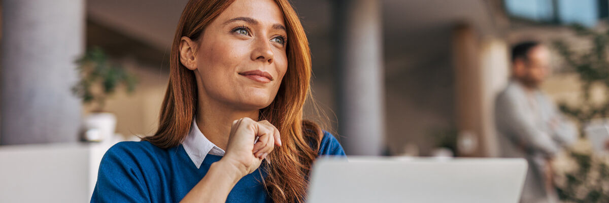 A businesswoman strategizes on device refresh and memory shortages for 2026 while working in her modern office, navigating the challenges of a tech-driven environment.