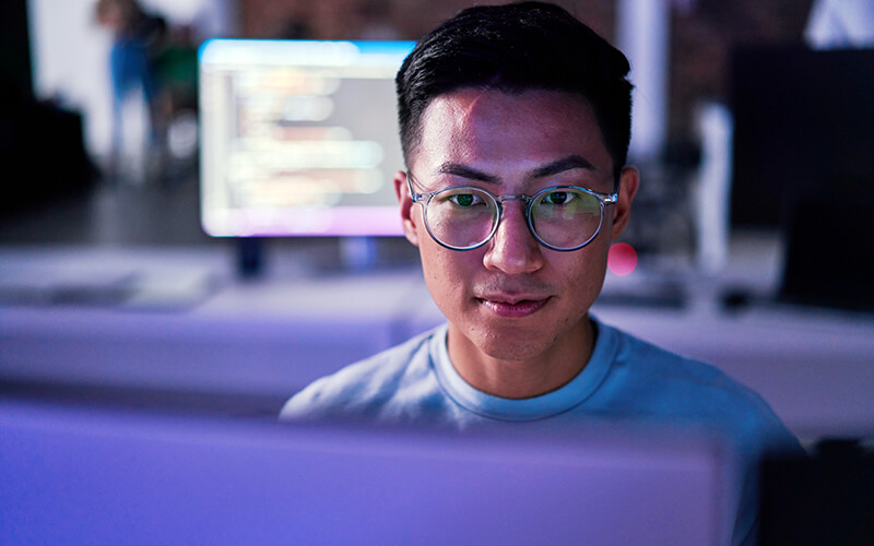 Software engineer codes on a laptop using Google Workspace tools within a professional workspace environment.