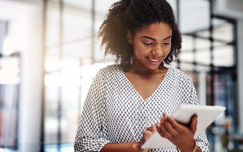 Smiling woman on tablet in bright open office
