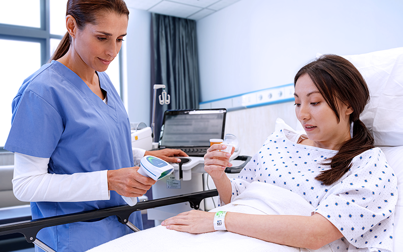Nurse using Zebra healthcare device to monitor patient in hospital Empower your clinicians to stay connected throughout the healthcare facility