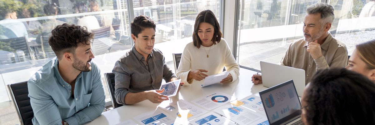 Group of business professionals gathered around in meeting