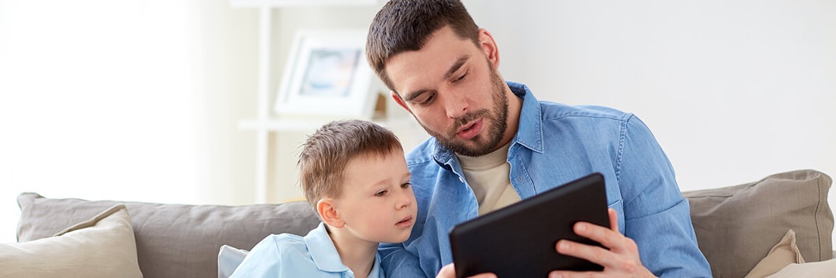 Dad using tablet computer with son.