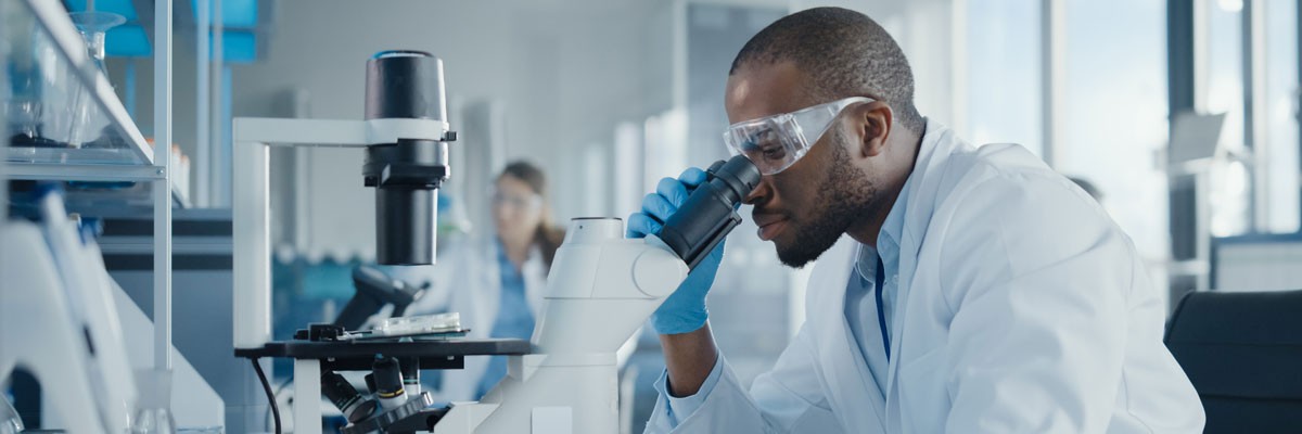 Pharmacist in research organization using microscope