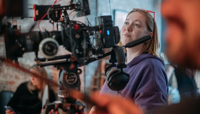 Two Insight colleagues collaborating on AI transformation data and project metrics displayed on a dashboard monitor.