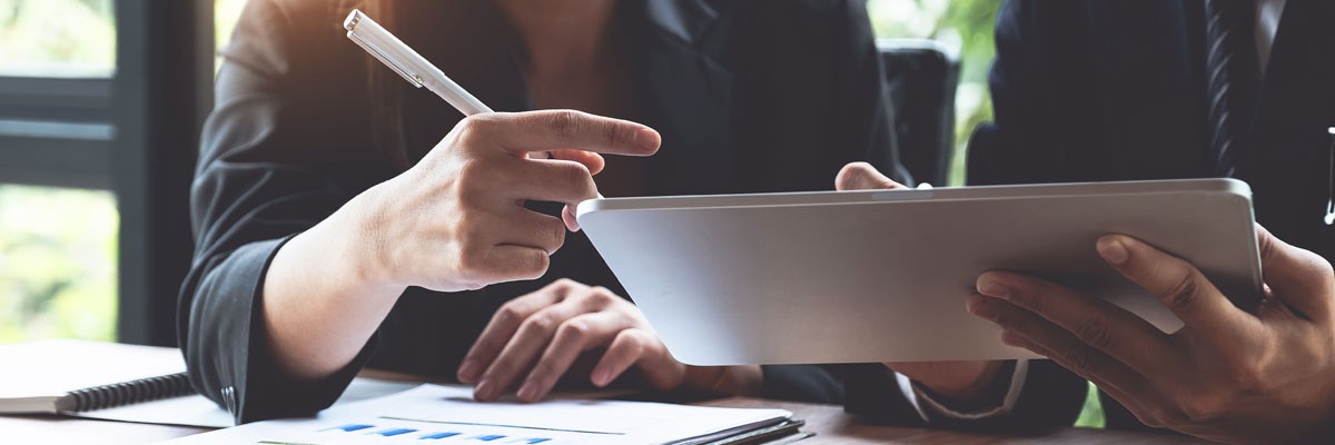 Close up of two business professionals looking at tablet device