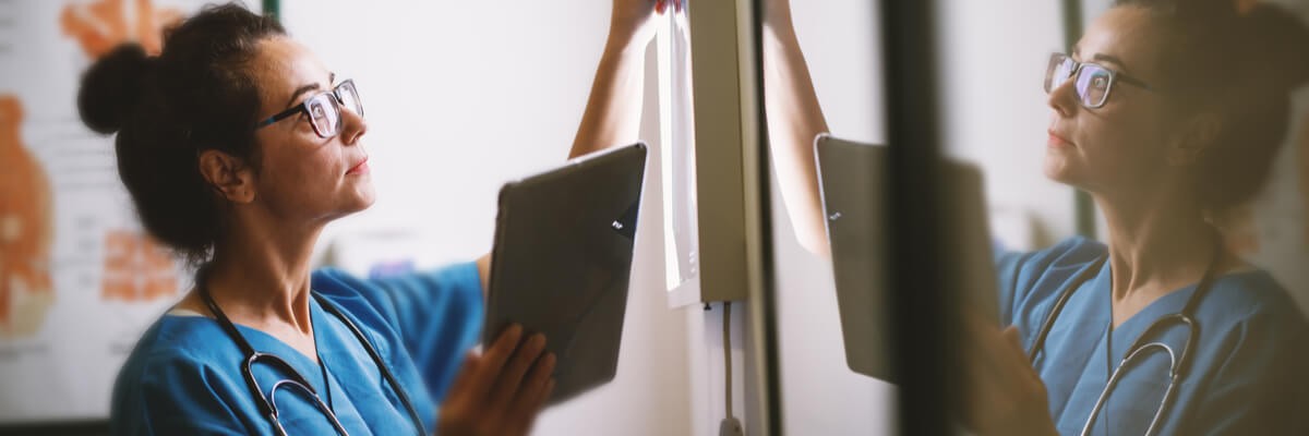 Nurse in hospice changing lighting in patient room.