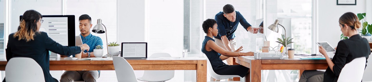 Business team works in modern workplace on multiple Apple iPad and Mac devices.