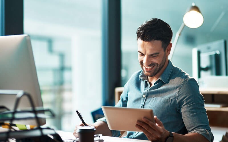 Man smiling holding tablet computer