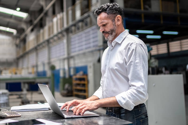 small-businessman-using-laptop-in-modern-factory