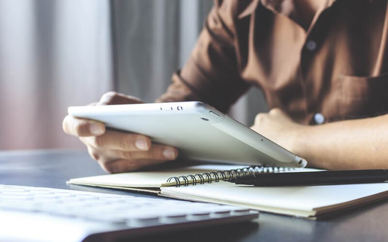 Two business professionals reading report on laptop computer