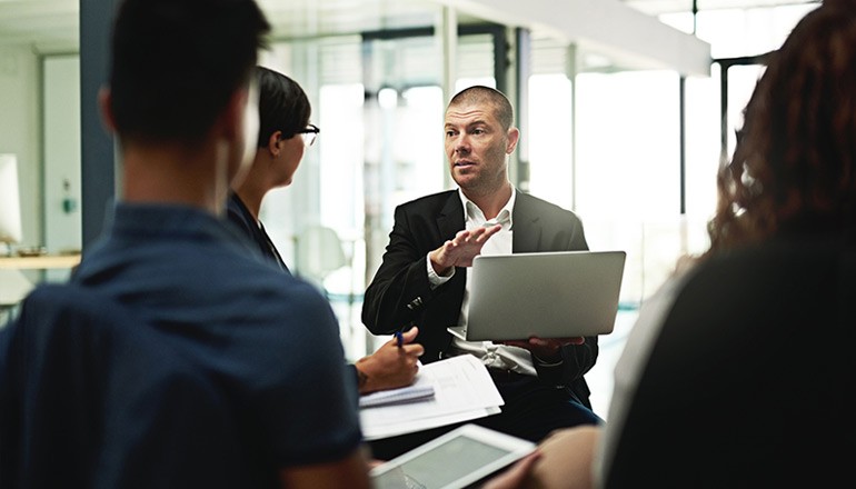Designing a World-Class IT Management Program Team discussing software asset management solutions