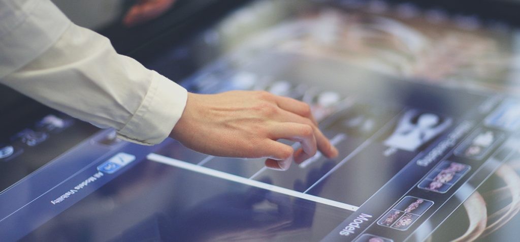 Doctor hand scrolling through large screen of models for their data