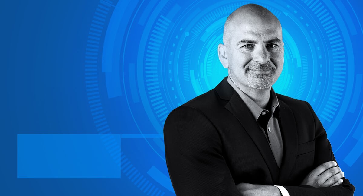 Doug Martin crosses arms in suit and smiles into camera