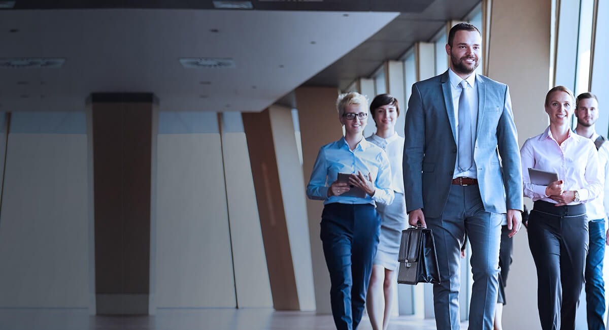 Prepared businessmen and businesswomen carrying computer tablets and briefcases