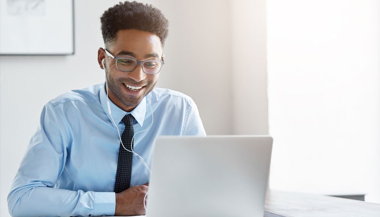 Smiling businessman on laptop working from home