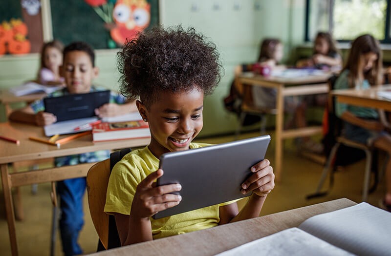 Young student using tablet device in classroom