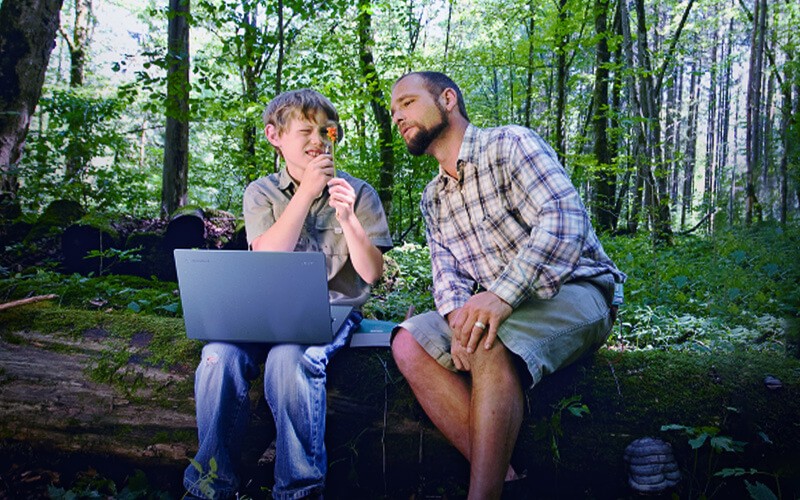 Man and a boy with laptop outdoor