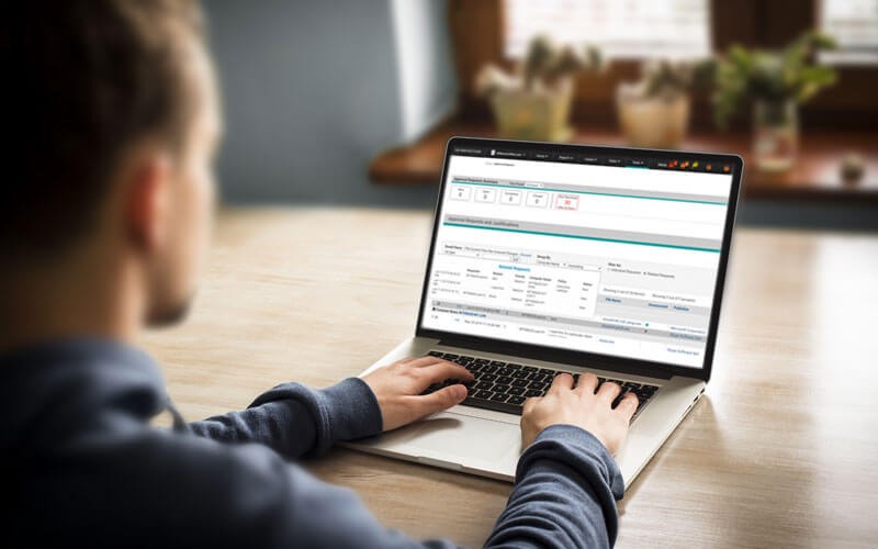 Male employee working on laptop with Carbon Black Protection displayed