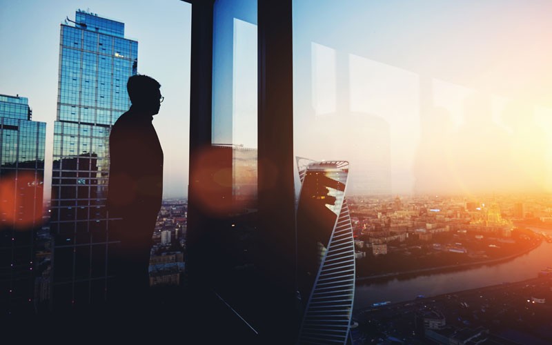 Silhouette of business man in building with skyscrapers
