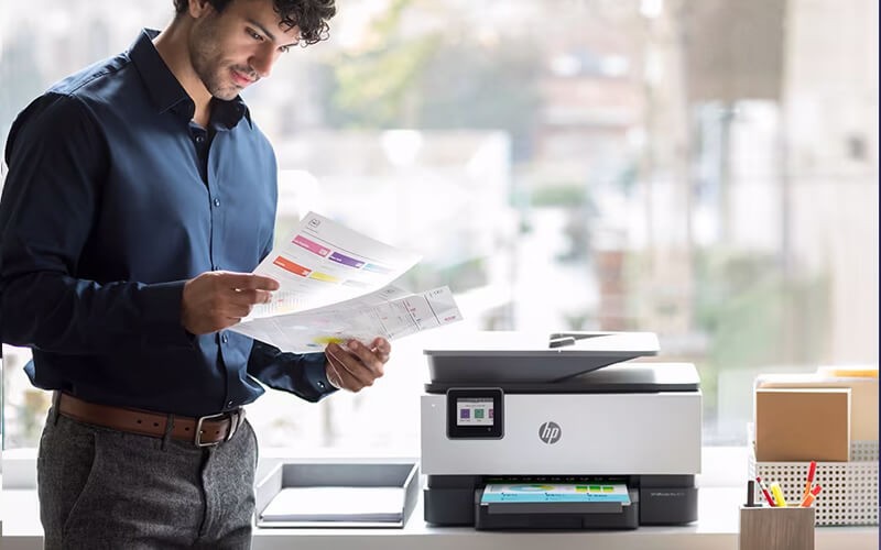 Man standing next to HP printer