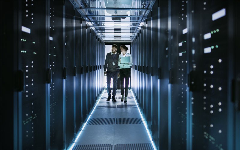 Two people walking through data center