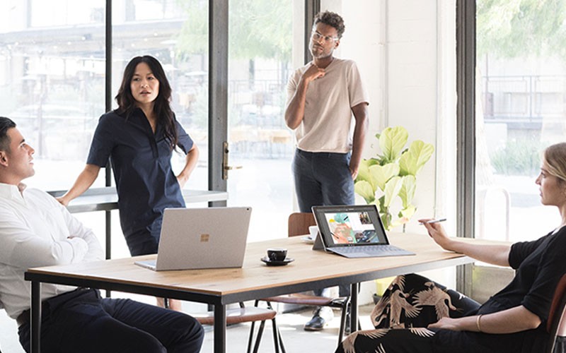 Office 365 allows you to maintain visibility and productivity Team collaborating using Microsoft Surface device