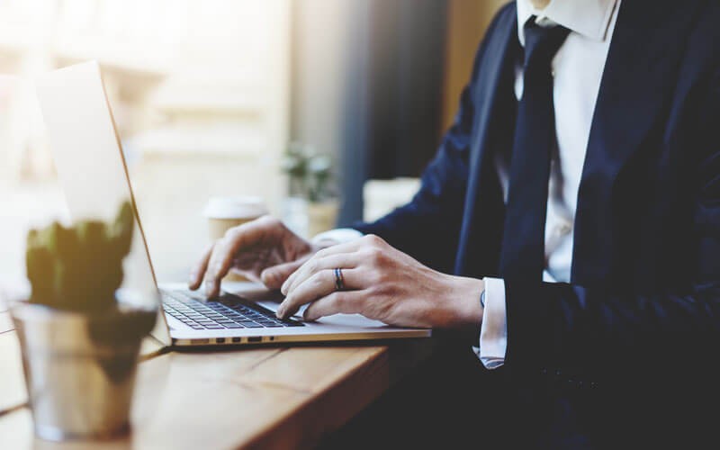 Business man typing on laptop keyboard