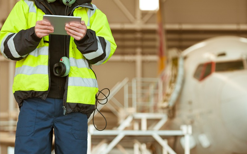 Airplane worker on ground using tablet