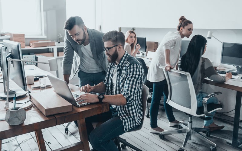 Various businessmen and women working in modern open office