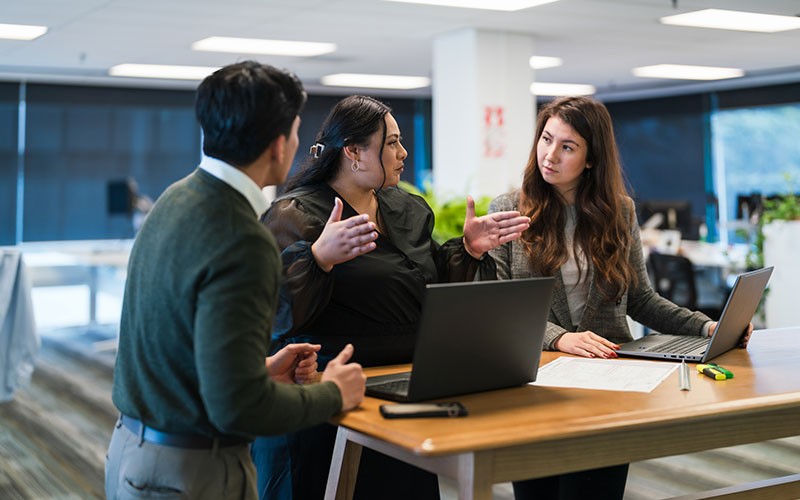 teammates-collaborating-in-office-table-discussing