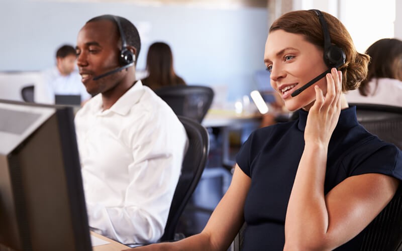Two call center representatives on headsets